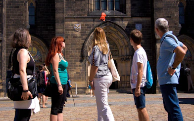 Tourists exploring Vyšehrad Castle's historic entrance in Prague.