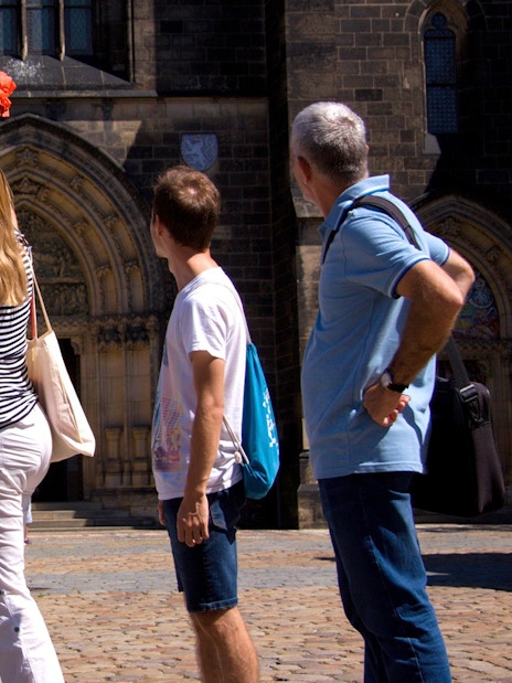 Tourists exploring Vyšehrad Castle's historic entrance in Prague.