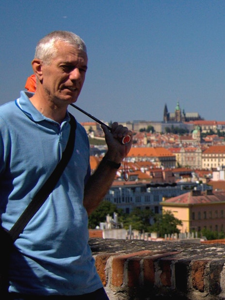 Tourists at Vyšehrad Castle with Prague cityscape in the background.