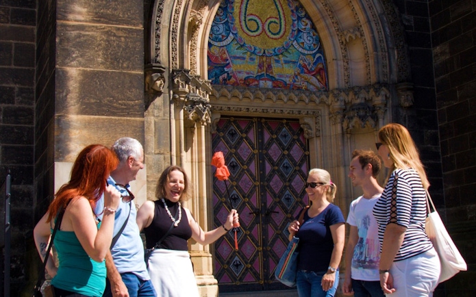 Tour group at Vyšehrad Castle entrance, Prague, with guide holding a flag.