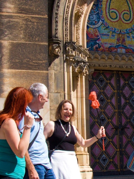 Tour group at Vyšehrad Castle entrance, Prague, with guide holding a flag.