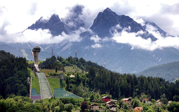 Bergisel Stadium ski jump with mountainous backdrop in Innsbruck, Austria.