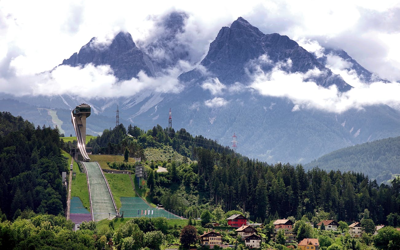 Bergisel Stadium ski jump with mountainous backdrop in Innsbruck, Austria.