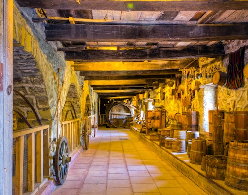 Traditional Greek cellar with wooden barrels and tools, part of Meteora tour from Kalabaka.