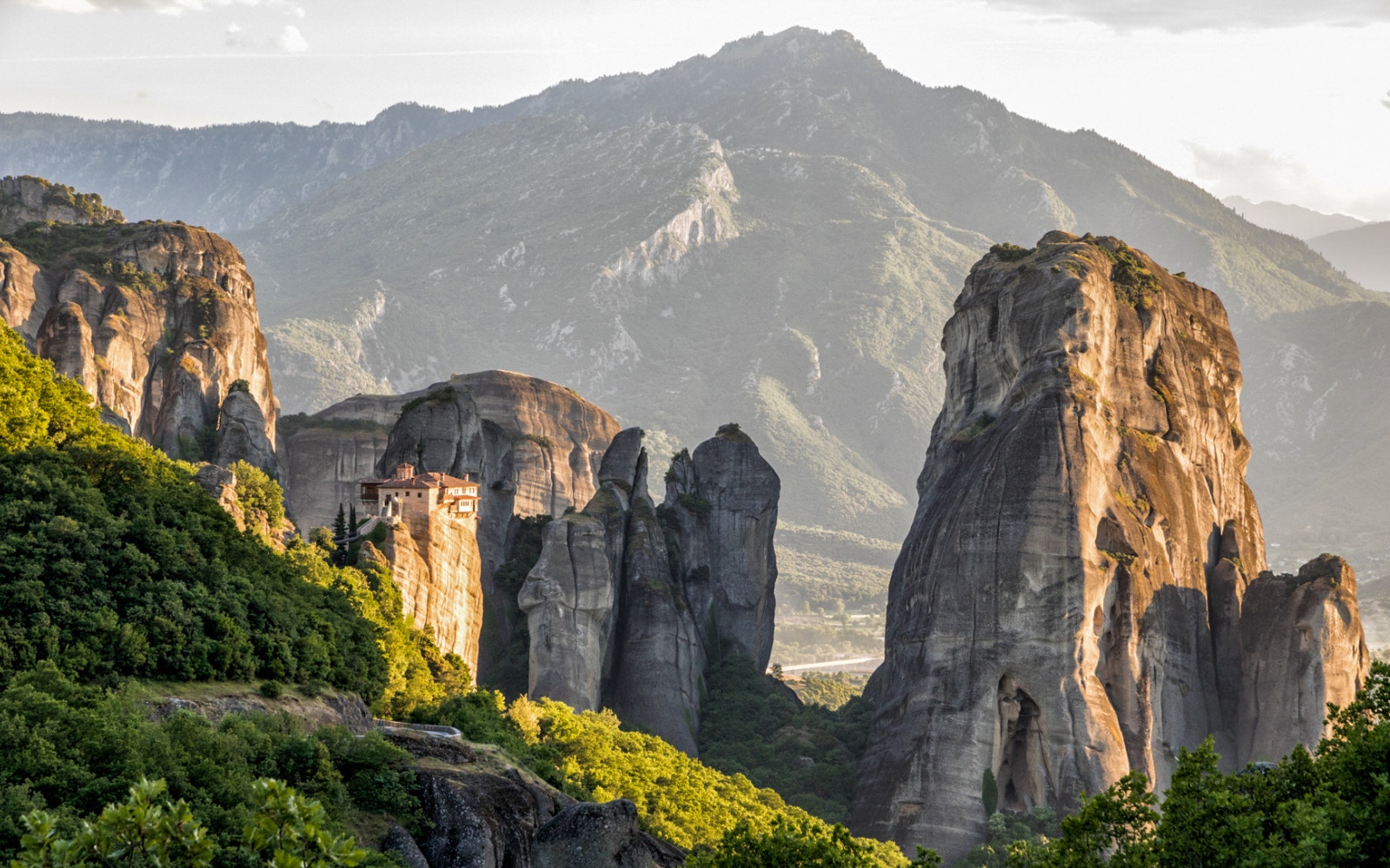 Meteora rock formations with a monastery perched on a cliff, viewed from Kalabaka, Greece.