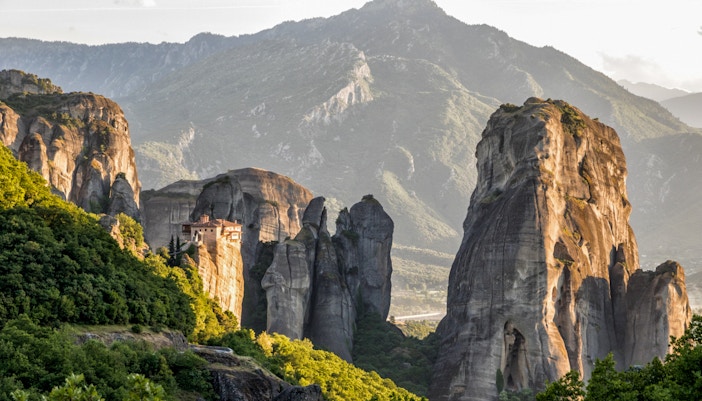 Meteora rock formations with a monastery perched on a cliff, viewed from Kalabaka, Greece.