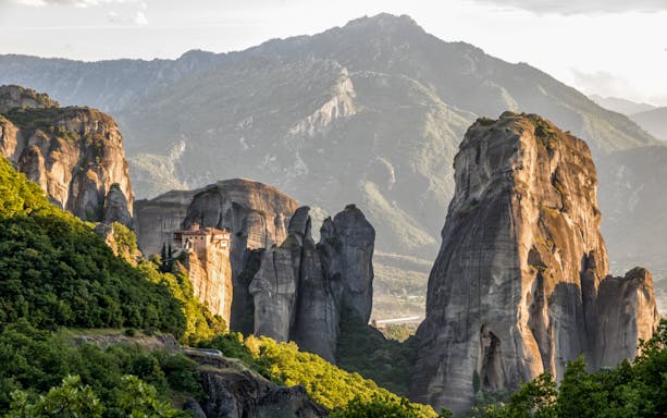 Meteora rock formations with a monastery perched on a cliff, viewed from Kalabaka, Greece.