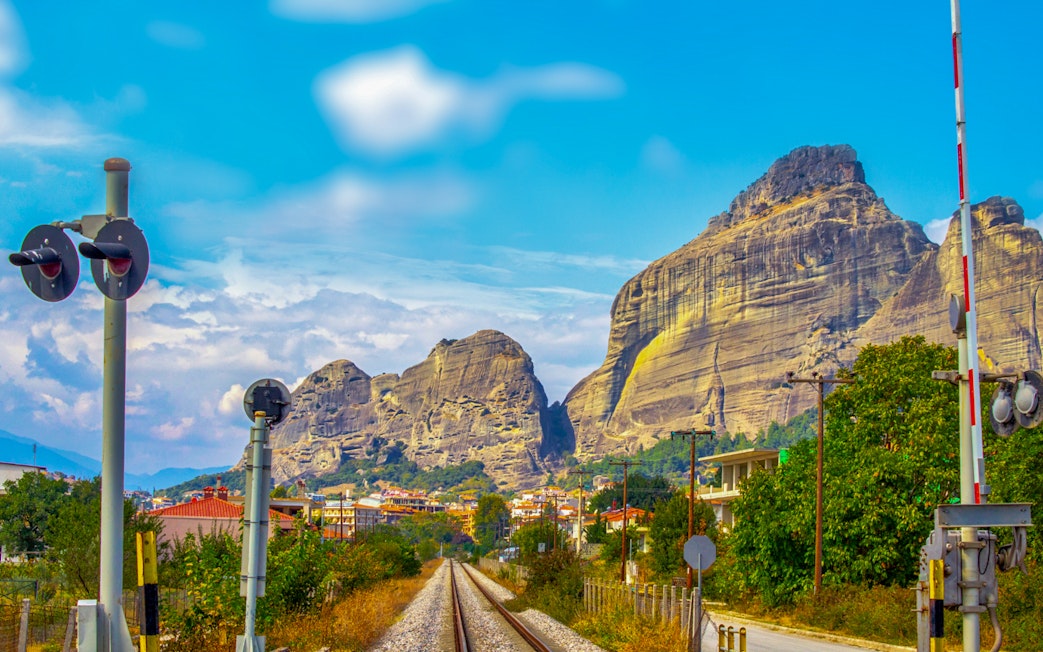 Railway tracks leading to Meteora rock formations in Greece.