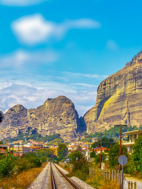Railway tracks leading to Meteora rock formations in Greece.