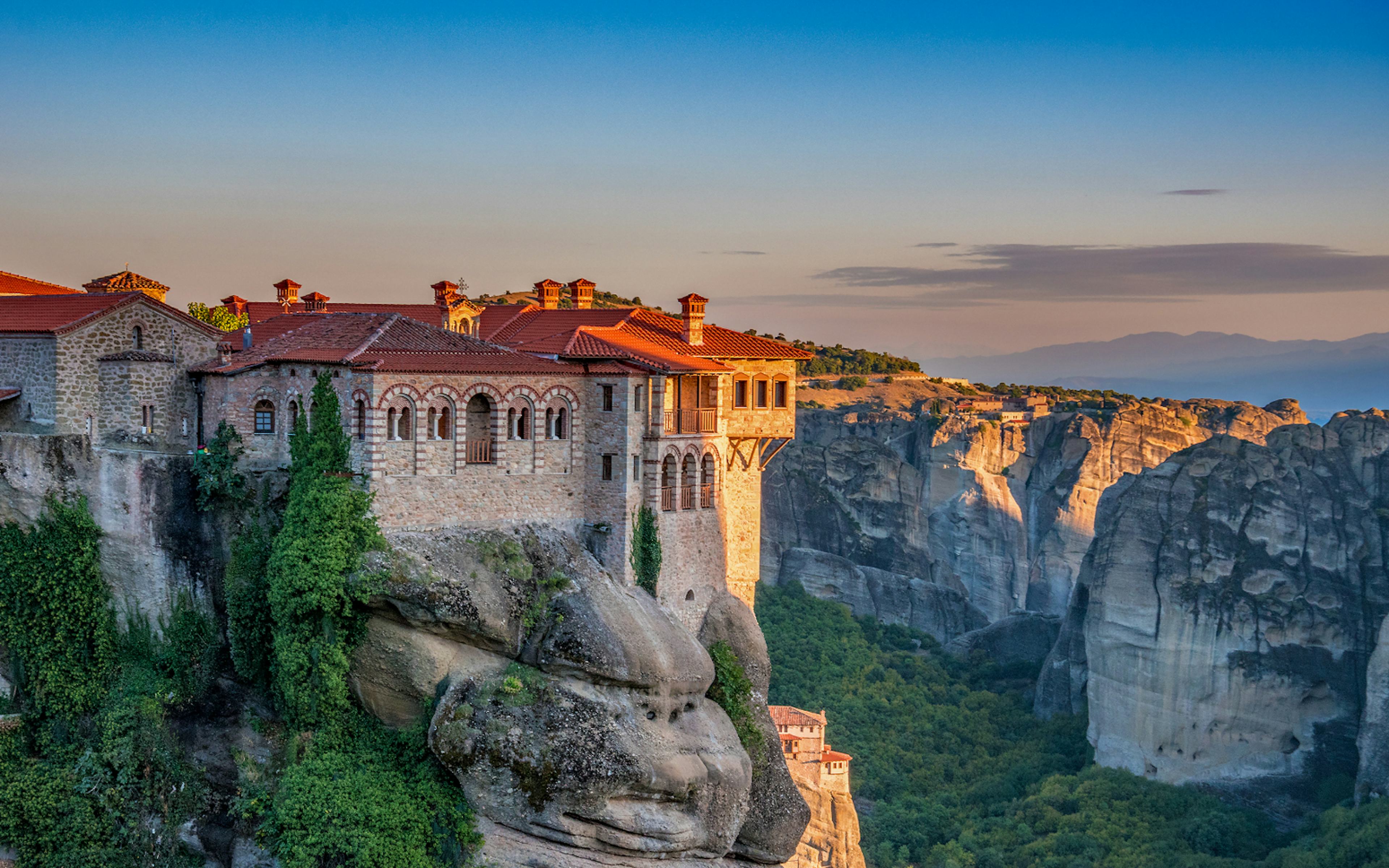 Meteora monastery perched on a cliff at sunset during Athens to Meteora full-day trip.