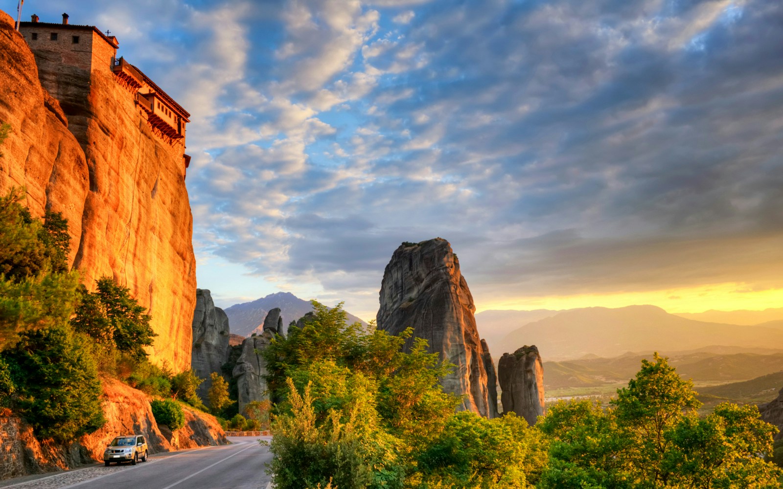 Meteora rock formations at sunset with a monastery perched on a cliff, Thessaloniki tour.