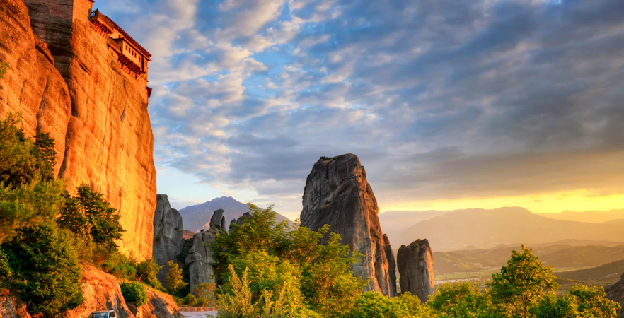 Meteora rock formations at sunset with a monastery perched on a cliff, Thessaloniki tour.
