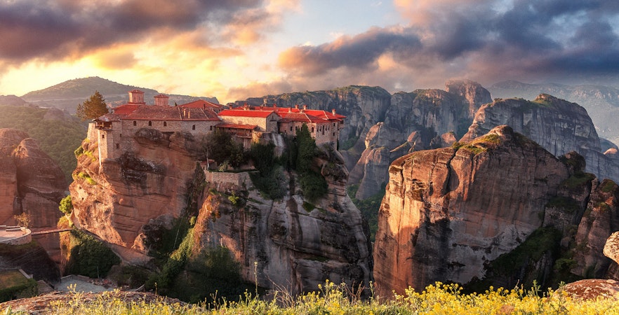 Meteora monasteries perched on rock formations at sunset, Thessaloniki tour destination.