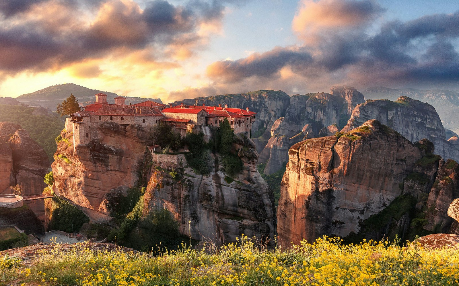 Meteora monasteries perched on rock formations at sunset, Thessaloniki tour destination.