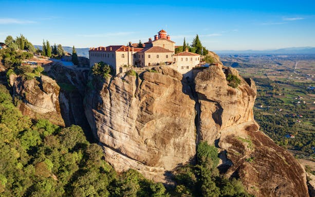 Monastery atop rock formation in Meteora, Greece, viewed during Thessaloniki train tour.