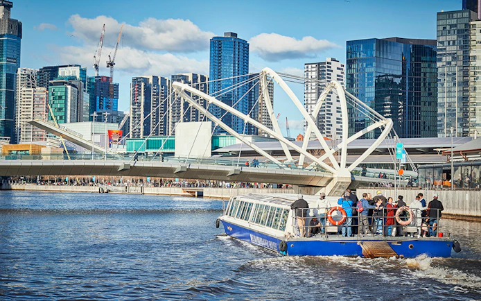 Ferry cruise on Yarra River with Melbourne skyline and Seafarers Bridge in view.