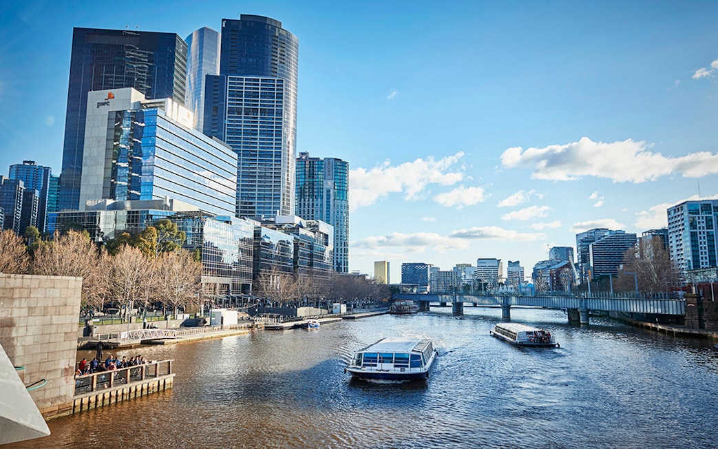 Ferry cruising on Yarra River with Melbourne city skyline in the background.