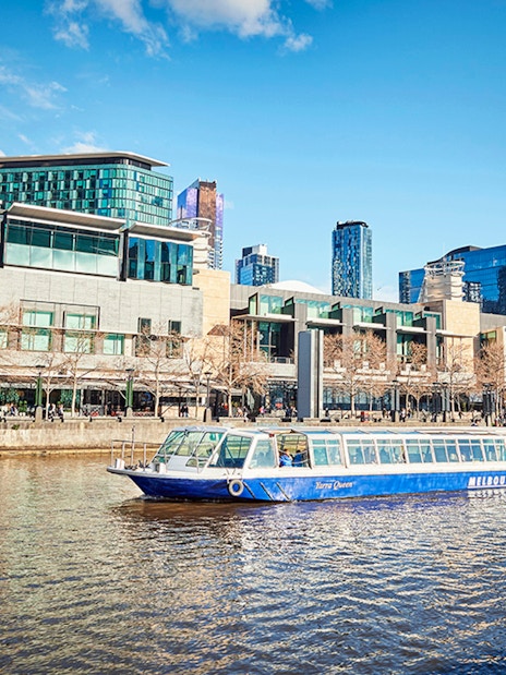 Ferry cruising on the Yarra River with Melbourne cityscape in the background.