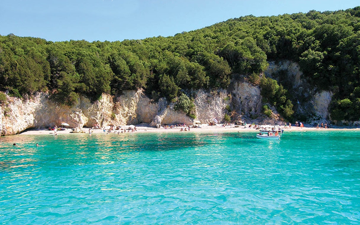 Crystal-clear waters and lush cliffs at Blue Lagoon, Sivota, during Corfu cruise with lunch.