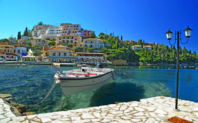 Boat docked in Sivota harbor with hillside buildings, part of Blue Lagoon & Sivota Cruise from Corfu.