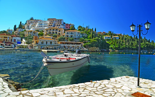 Boat docked in Sivota harbor with hillside buildings, part of Blue Lagoon & Sivota Cruise from Corfu.