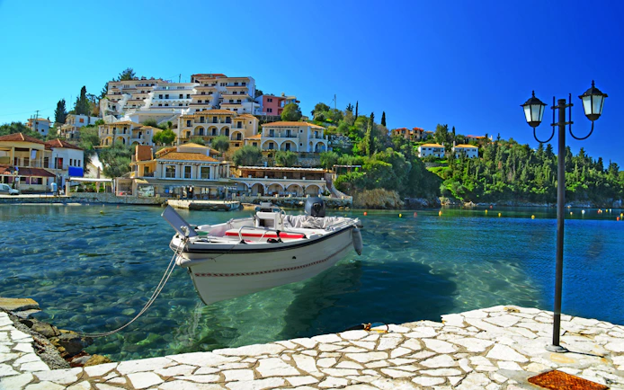 Boat docked in Sivota harbor with hillside buildings, part of Blue Lagoon & Sivota Cruise from Corfu.
