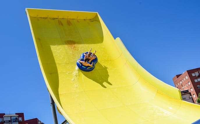 Visitors on a yellow water slide at Guadalpark, Seville.