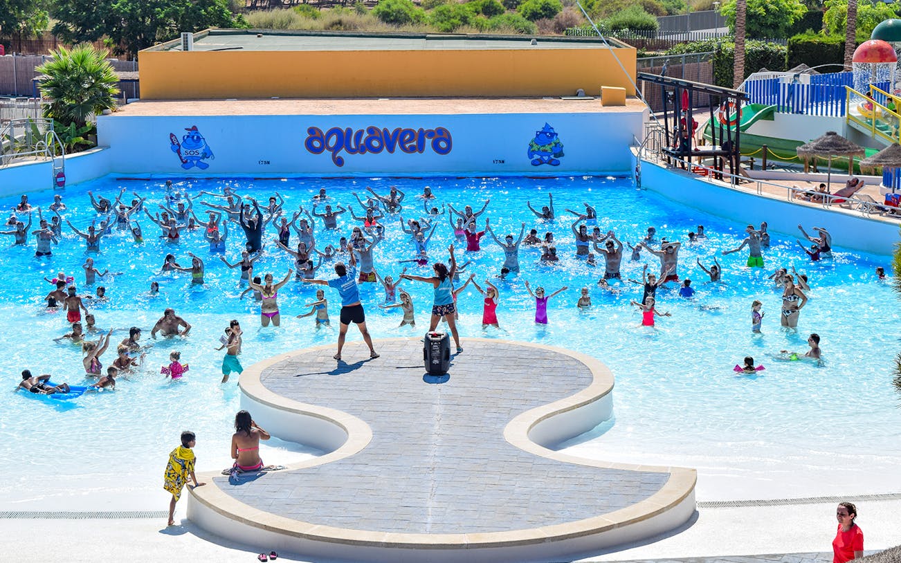 Visitors enjoying a wave pool at AquaVera Water Park with instructors leading activities.