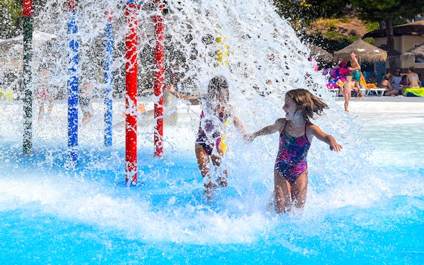 Children playing under water jets at AquaVera Water Park.