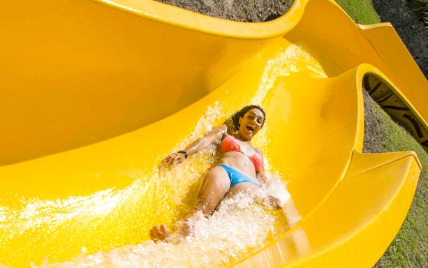 Person enjoying a water slide at Aqualeon Water Park, Tarragona.