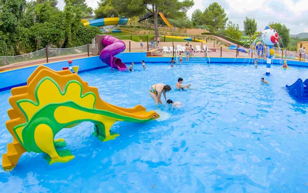Children playing in a pool with slides at Aqualeon Water Park, Tarragona.
