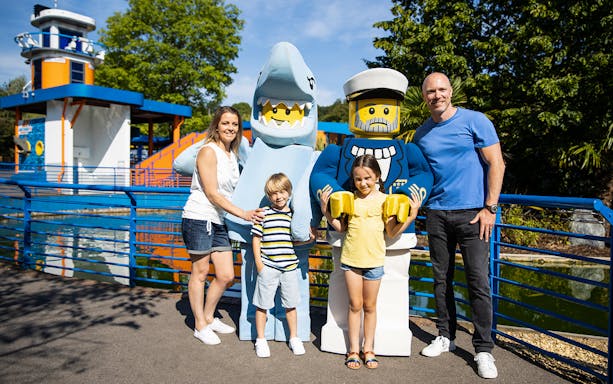 Family posing with Lego characters at Legoland New York.
