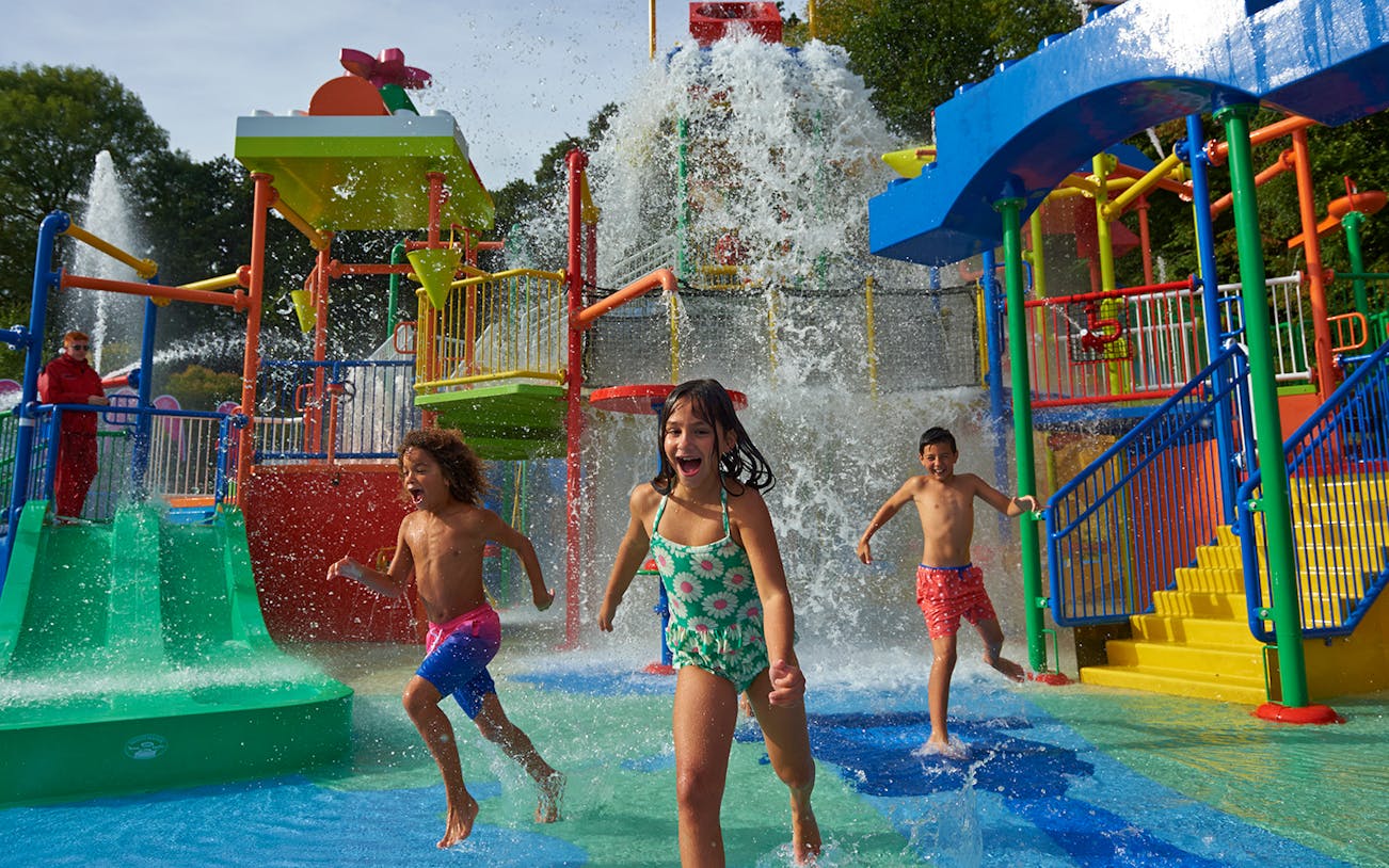 Children playing in a colorful water park at Legoland New York.