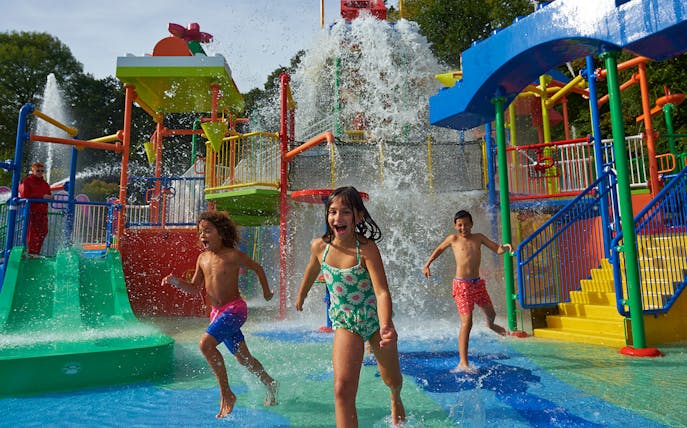 Children playing in a colorful water park at Legoland New York.