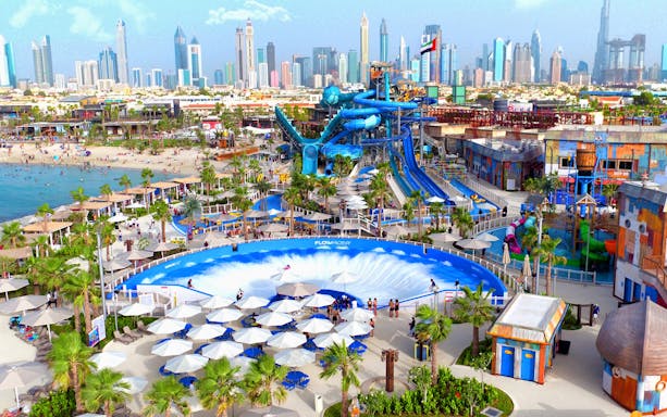 Laguna Waterpark with Dubai skyline, featuring water slides and wave pool.