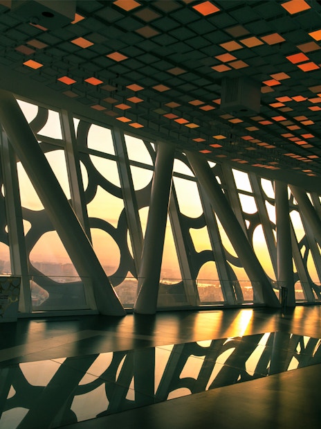 Interior view of Dubai Frame with city skyline at sunset.