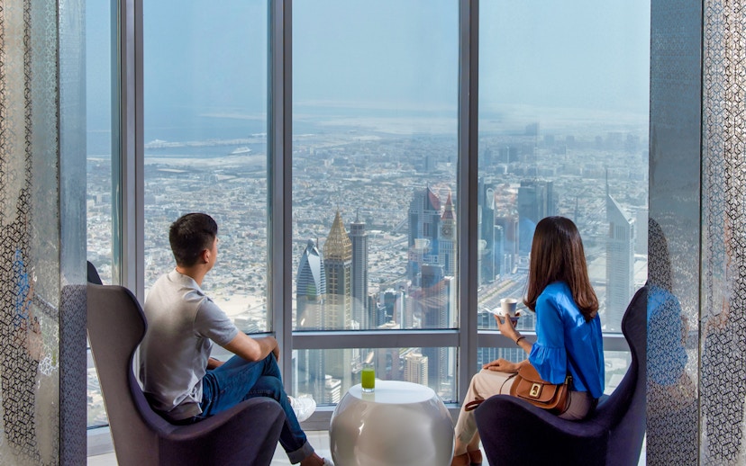 Visitors enjoying the view from Burj Khalifa, overlooking Dubai skyline.
