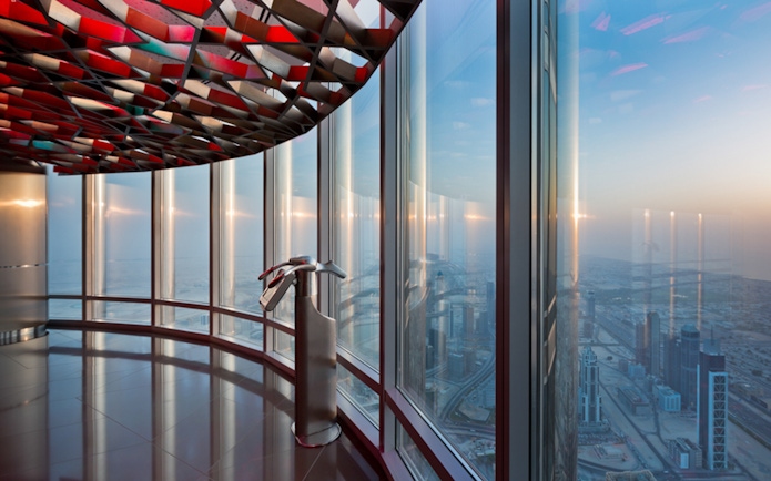 Burj Khalifa observation deck view of Dubai skyline at sunset.