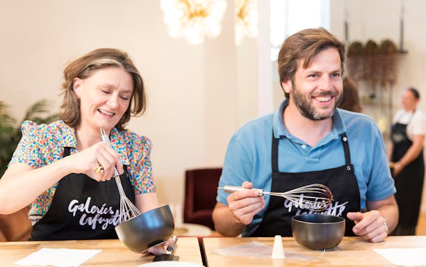 Participants whisking ingredients at Cours de Macarons, Galeries Lafayette.