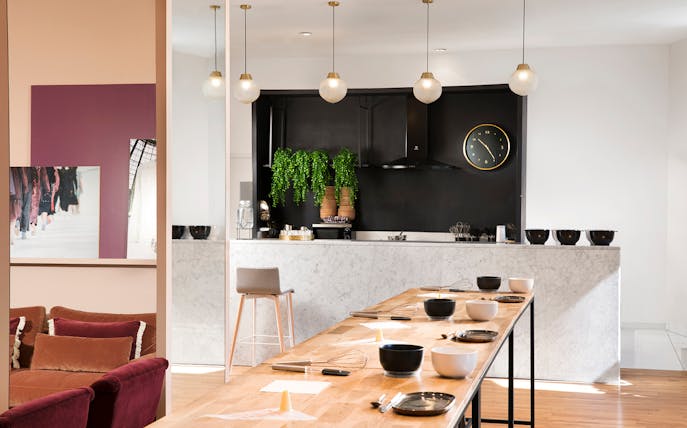 Macaron class setup at Galeries Lafayette with bowls and whisks on a wooden table.