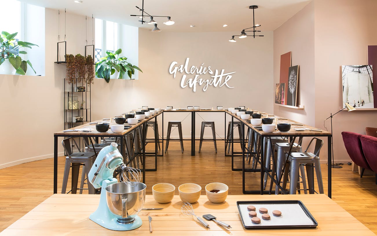 Macaron baking class setup at Galeries Lafayette, Paris with mixing bowls and ingredients.