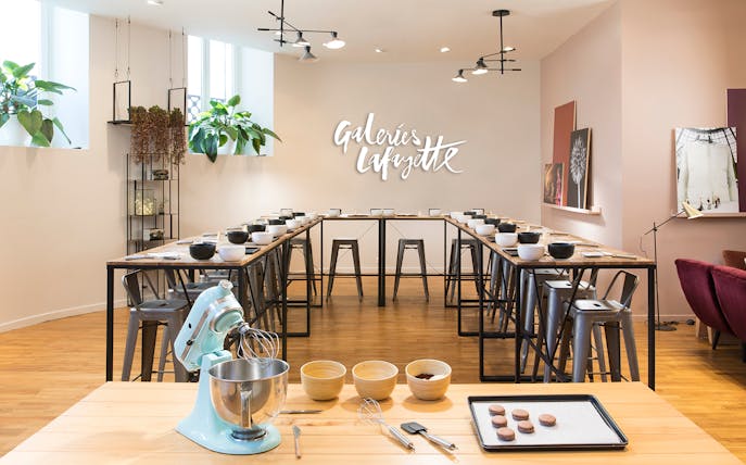Macaron baking class setup at Galeries Lafayette, Paris with mixing bowls and ingredients.