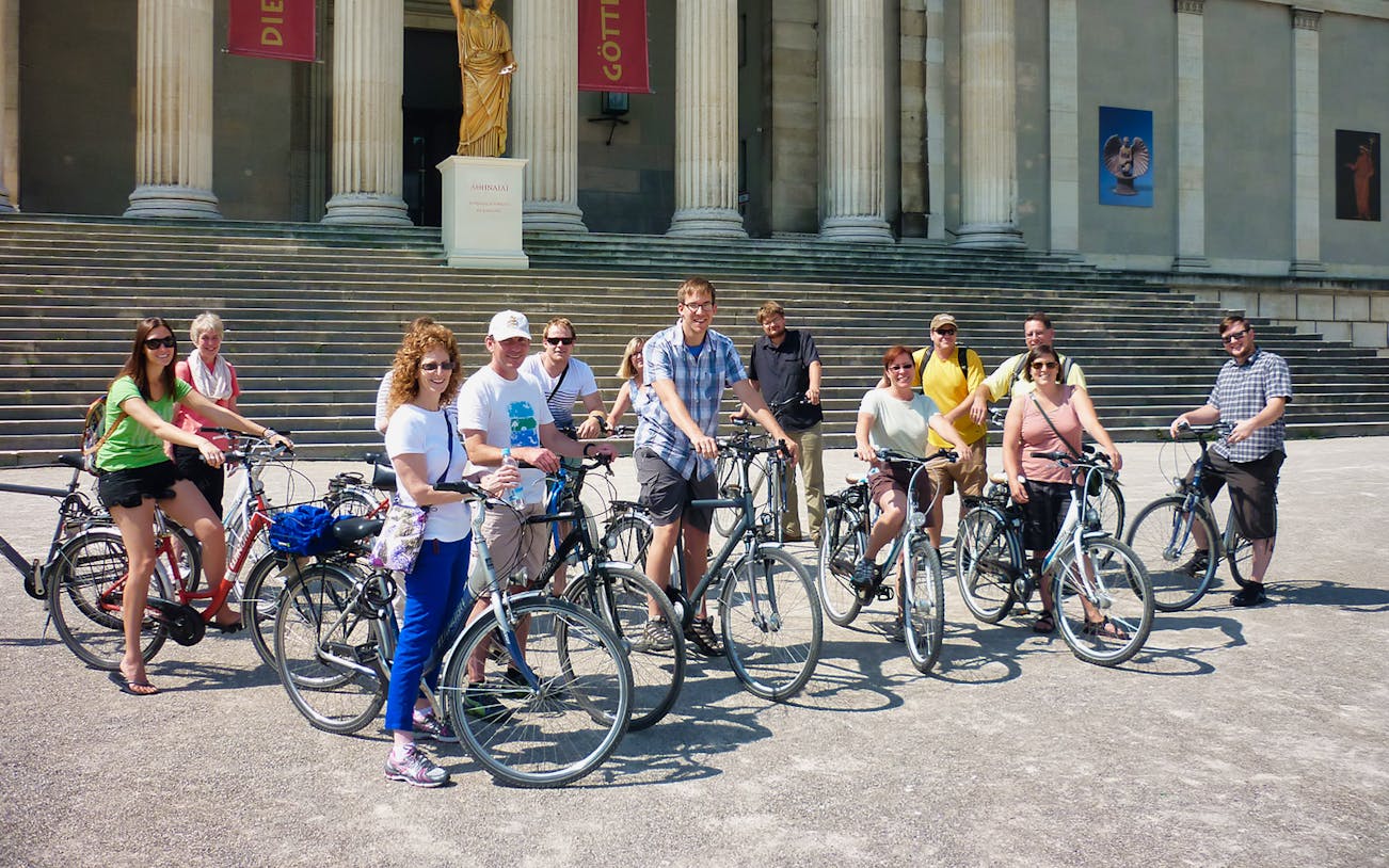 Group of cyclists in front of a historic building during a Munich bike tour.