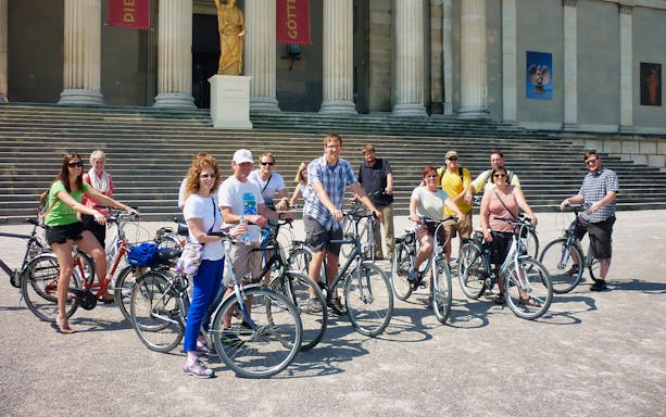 Group of cyclists in front of a historic building during a Munich bike tour.