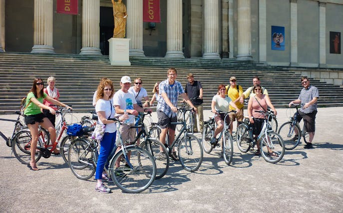 Group of cyclists in front of a historic building during a Munich bike tour.