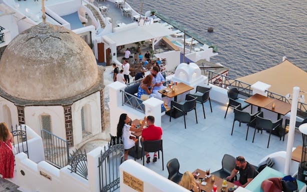 Outdoor dining area overlooking the sea in Santorini near the cable car station.