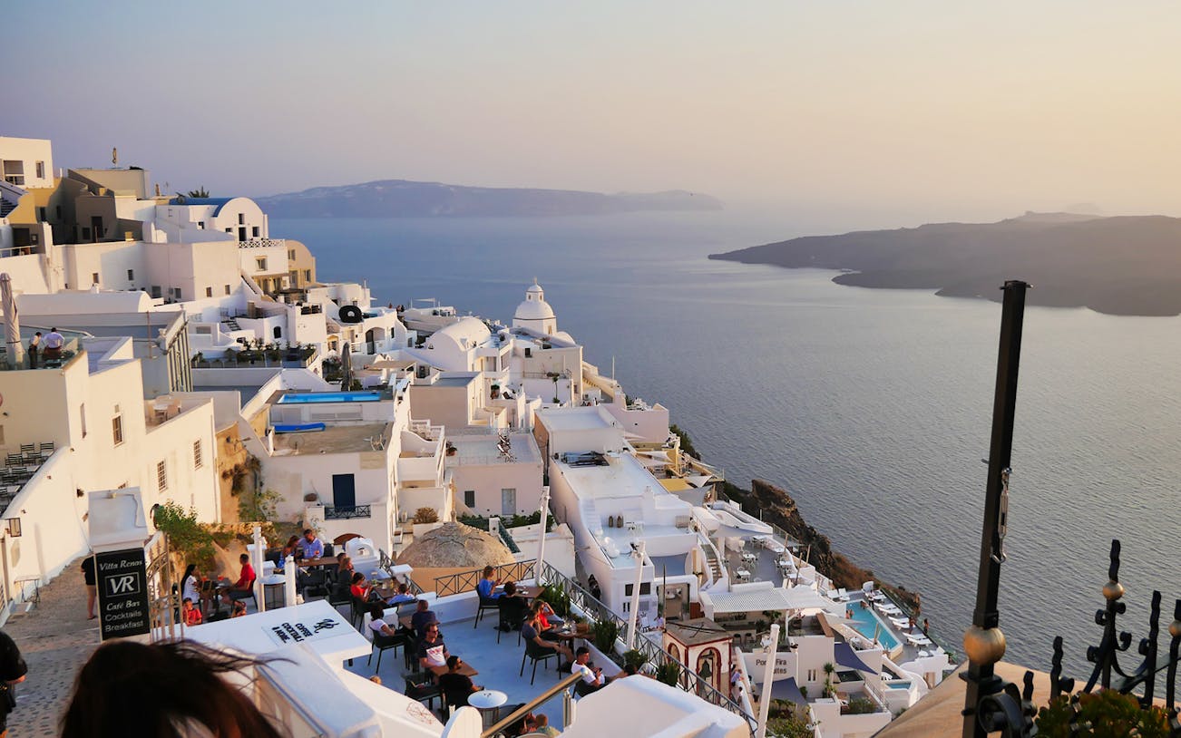 Santorini view with white buildings overlooking the Aegean Sea, seen from a cable car vantage point.