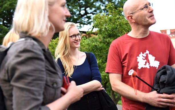 Group enjoying an evening walking tour with entrance tickets in hand.