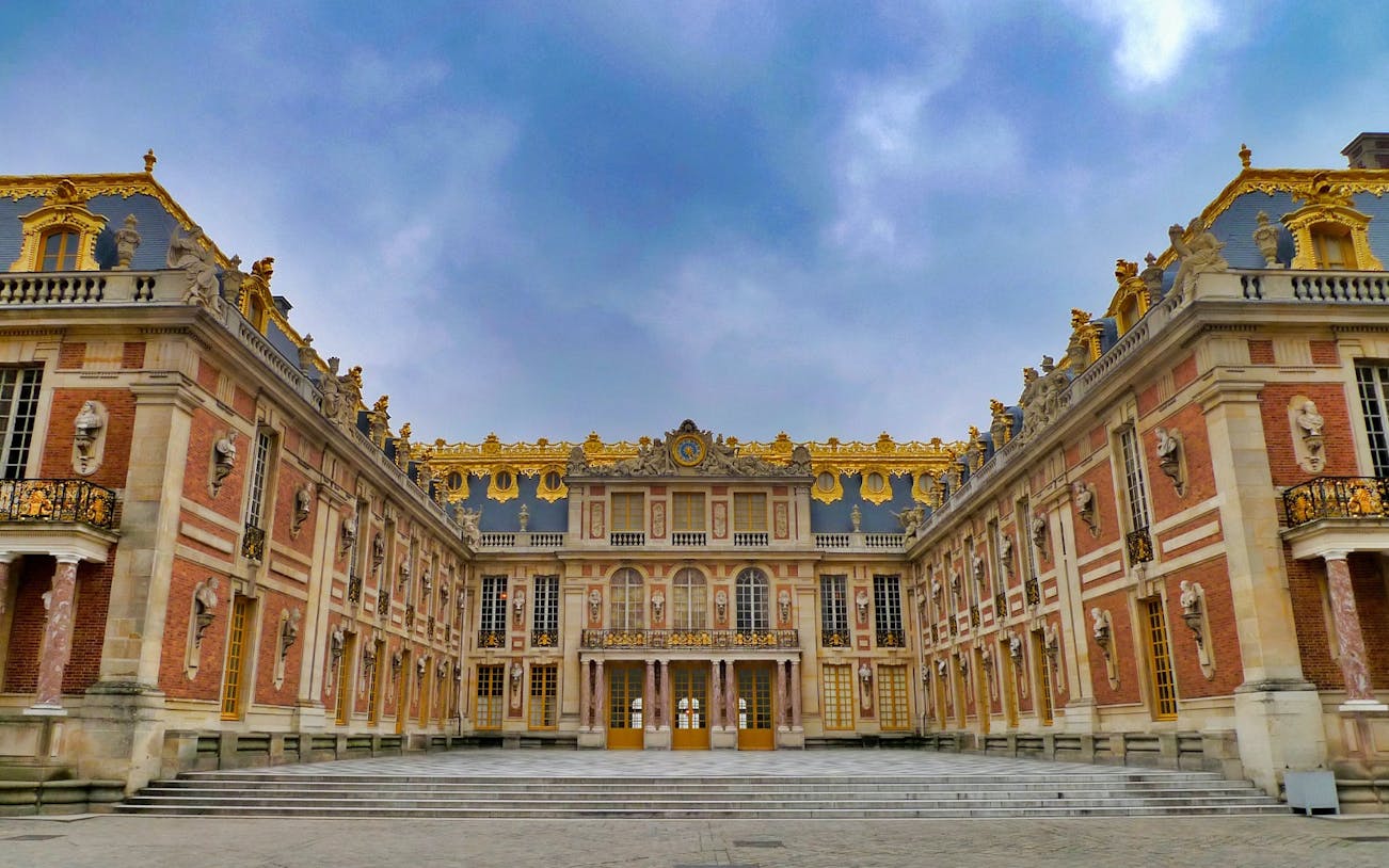 Versailles Trianon courtyard with ornate architecture and golden details.