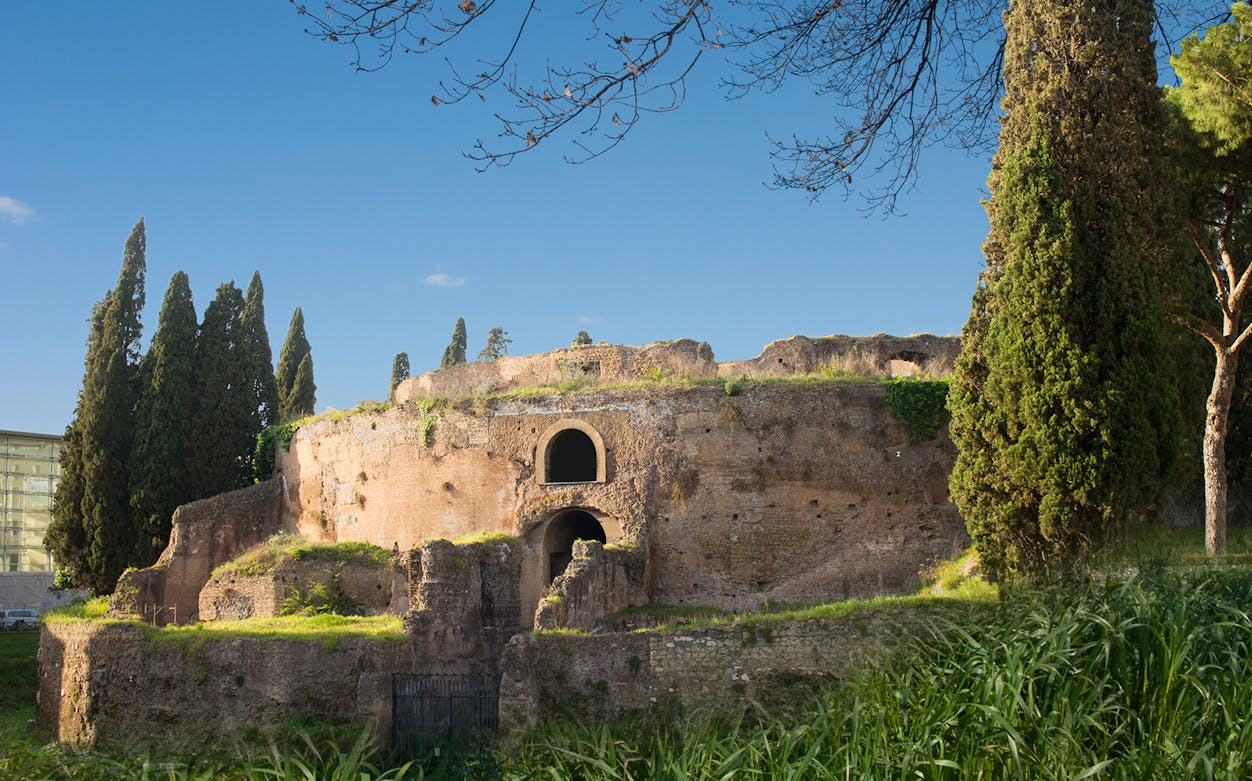 Mausoleum of Augustus with ancient brick structure and surrounding cypress trees in Rome.